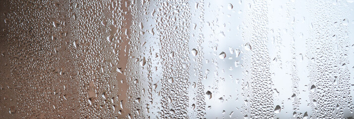 A photo of the glass surface of the window, covered with a multitude of droplets of various sizes....
