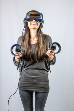 Junge Frau spielt belustigt mit Virtual Reality Datenbrille