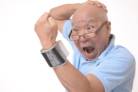 血圧を測定し驚くシニア