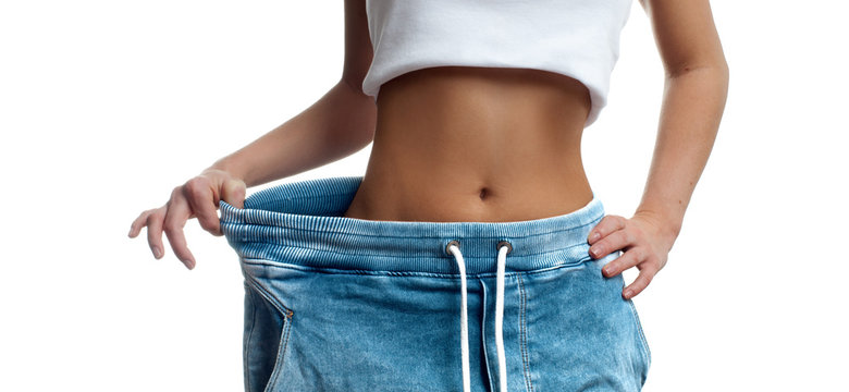 Woman in oversize jeans after weight loss.