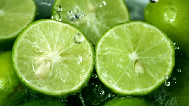 Limes Cut with Water Drops Slow Motion 