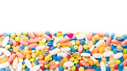Fototapeta na wymiar pills border over white. colorful pills isolated on white