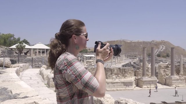 Tourist photographing ampitheater ruins at Beit Shean