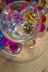 Fototapeta na wymiar diamonds in transparent cup on the pine wood table