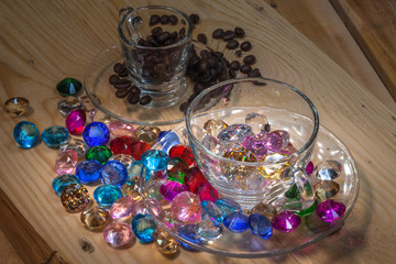 colorful gemstones on pine wood table with coffee cup