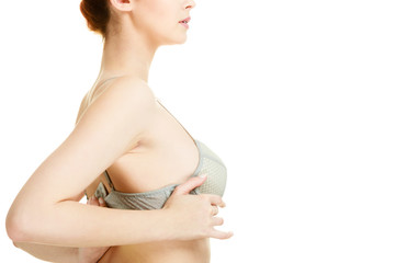 Fototapeta premium Attractive slim woman taking off grey bra