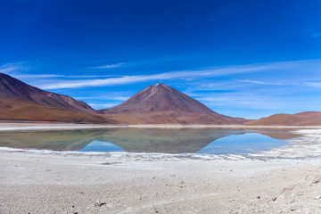 The natural colors of the green lagoon in the Siloli desert near the border of Chile and the Uyuni Salt Flat in Bolivia, South America