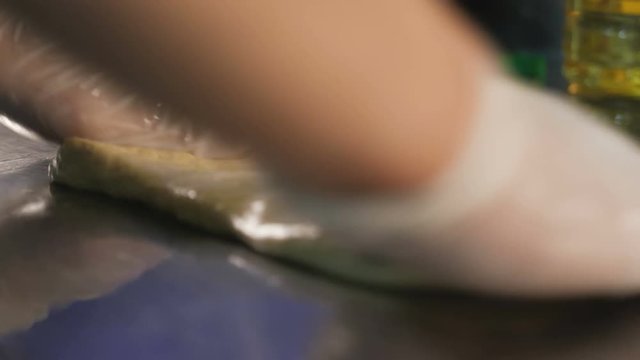Baker hands kneading dough on table