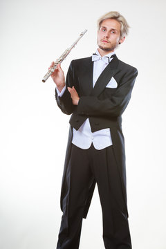 Male flutist wearing tailcoat holds flute