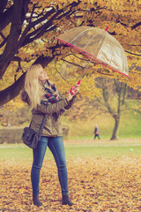 Woman walking in park with umbrella