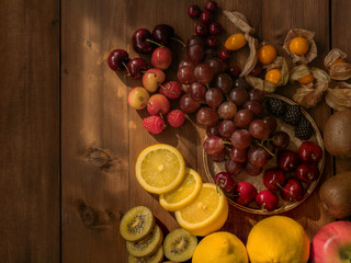 The flat lay still life image of varieties of fruits on wooden table
