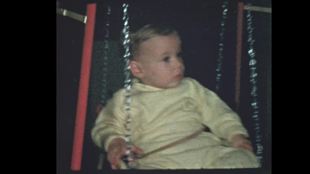 1953 1 year old baby boy swings on baby swing