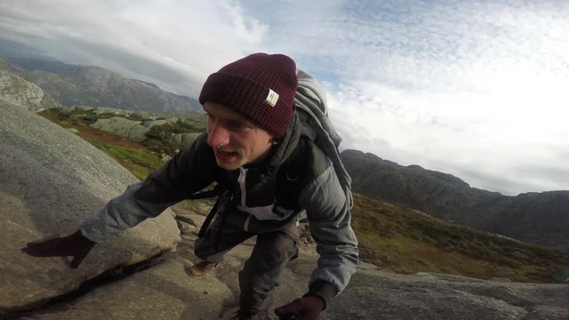 Young man hiking up a mountain in Norway