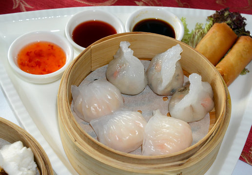 Dim Sum, Dumplings and Chinese buns on plate in bamboo basket