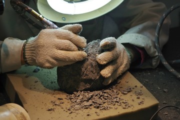 研究室で岩石を掘削する人