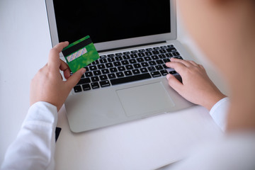 Business Woman Hands holding plastic credit card and using laptop smart phone Online shopping concept.