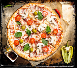 Fresh pizza with mushrooms, bacon and tomatoes.