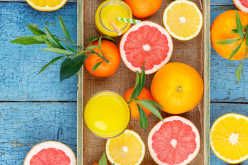 Different fruits and glass with fresh orange juice