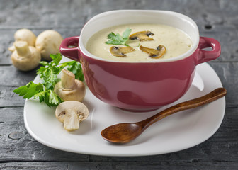 Cream soup of mushrooms with parsley on a wooden table.