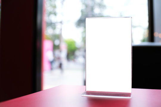 Mock up Menu frame standing on wood table in Bar restaurant cafe. space for text