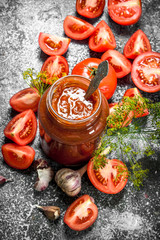 Tomato sauce with garlic and herbs in a glass jar.
