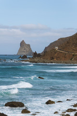 Fototapeta na wymiar Remote road on coastline next to the beach with crashing waves