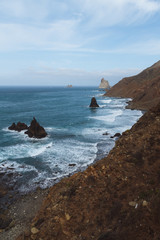 Remote beaches on coastline next to the mountains with crashing waves in ocean
