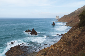 Remote beaches on coastline next to the mountains with crashing waves in ocean