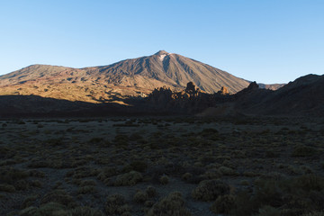 Sunrise light on volcano in desert landscape