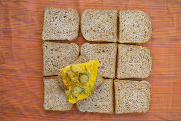 wedge of zucchini omelette on a background of sandwich bread