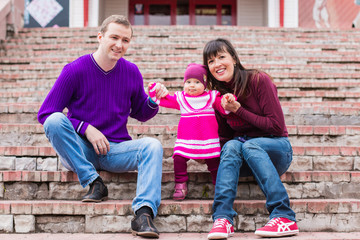 Dad, mom and little baby on the steps