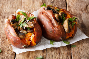 Homemade baked sweet potato stuffed with mushrooms, greens and cheese close-up. horizontal