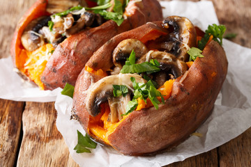 Baked whole sweet potato with mushrooms and cheese close-up. horizontal