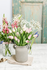 Bouquet of pink tulips in grey ceramic jug.