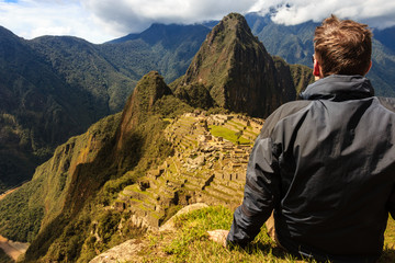 Hiker enjoying the view of Machu Picchu after a strenous ascent / Rastender Wanderer mit Blick auf Machu Picchu