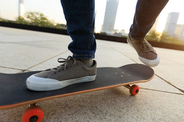 skateboarder legs riding with skateboard at city