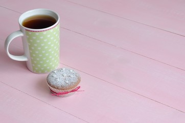 Muffin with hearts and cup of tea