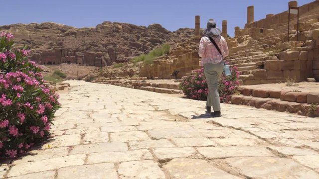 Tourist walks on the roadway inside Petra