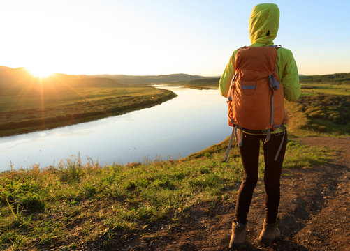  woman hiker enjoy the sunset view on riverside hill top