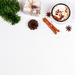 Cup of hot chocolate topping with marshmallow and gift box on white background. Top view. Christmas background.