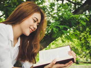 Obraz premium Young woman reading book at the park.
