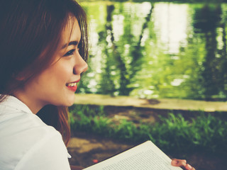 Young woman reading book at the park.