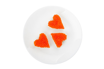 Three sandwiches with red caviar in the shape of heart lie on a white plate isolated on white background. Top view.