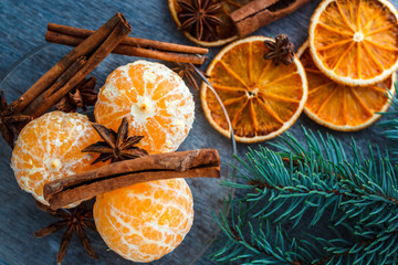 Mandarins, dried oranges, anise and cinnamon sticks on a wooden table