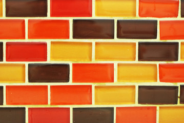 Fototapeta na wymiar The bright orange and yellow glass brick wall texture wall.