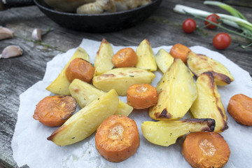 Appetizing baked vegetables, potatoes and carrots in rustic style.