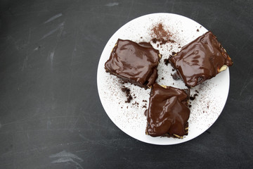 Appetizing chocolate cakes are located on a white plate close-up and copy space.