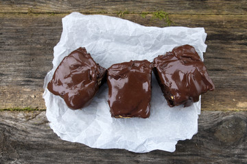 Appetizing chocolate cakes are located on an old wooden background.