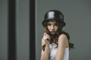 seductive young girl in military helmet, isolated on grey