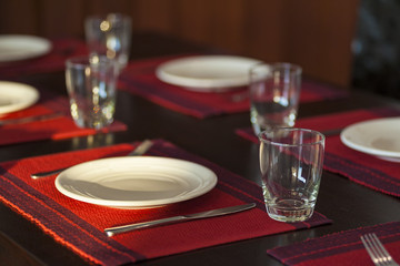 Restaurant table setting with empty glasses;red cloth plate
